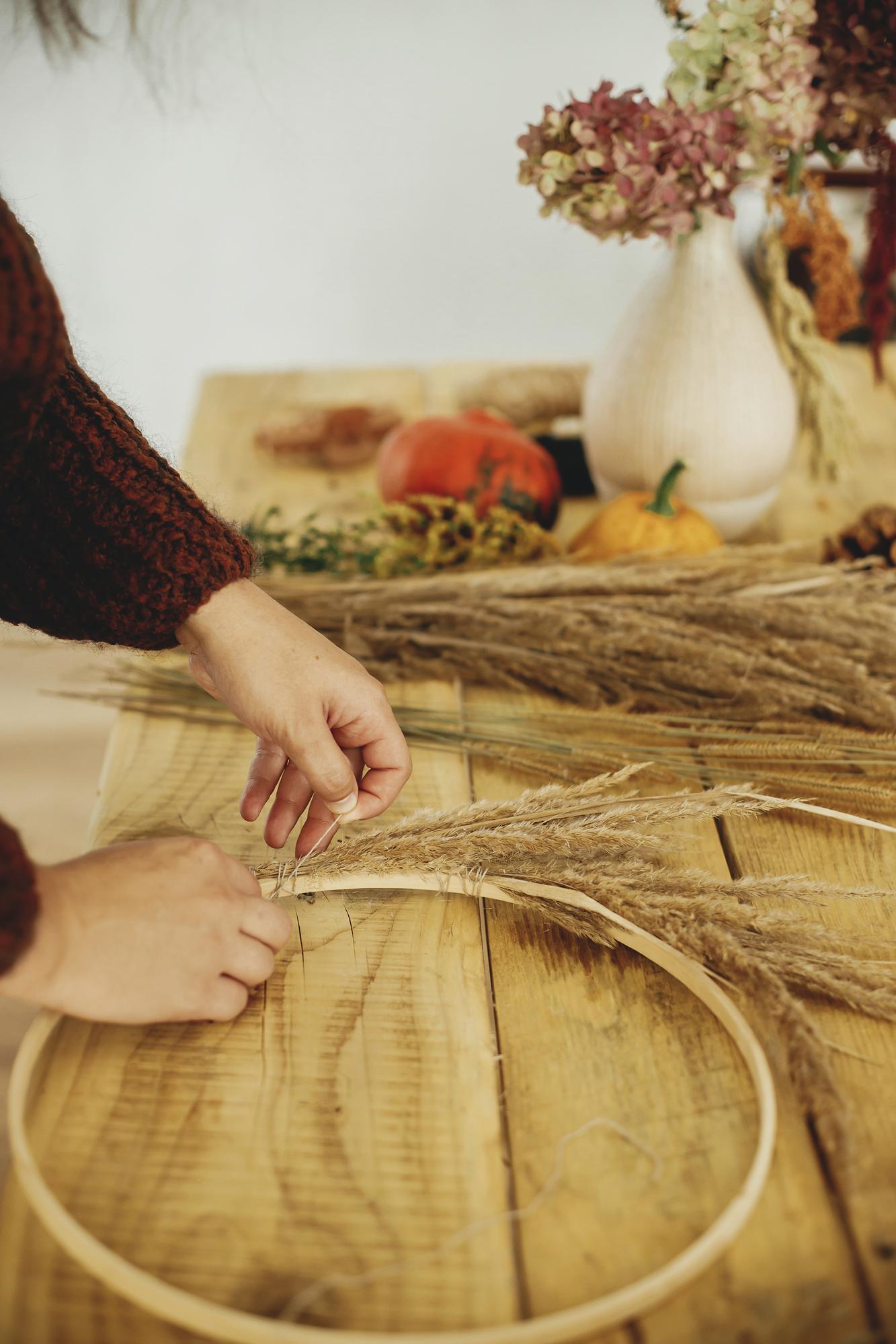 Hands preparing thread and hoop for embroidery